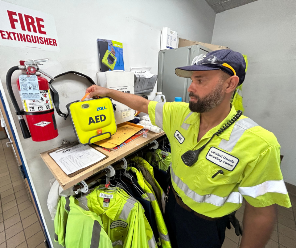 Waste Abatement Supervisor Khalid Alasadi picks up the AED machine at the Recycling Center Plus.