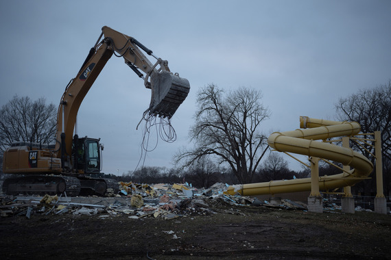 An excavator salvages metal from the deconstructed YMCA