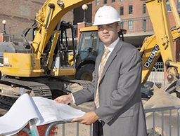 Photo of man in hard hat with plans
