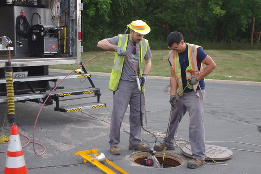 Caption: Nathan Kahler and Randall Mateo, interceptor service workers, conducting CCTV inspections. 