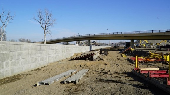 concrete wall being constructed underneath a bridge