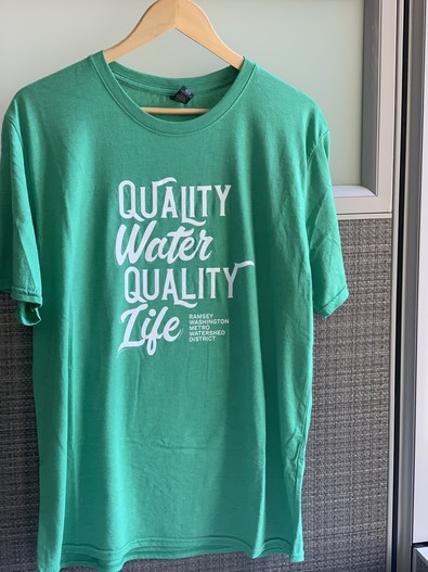 Green T-shirt that says, "quality water quality life"