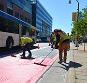 Workers paint new bus lane on Chicago Avenue