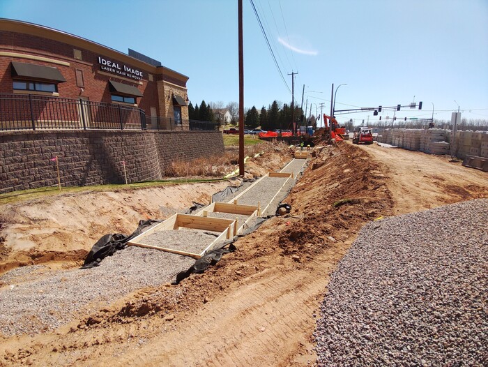 Crews build retaining wall foundations near Tamarack Road in Woodbury.