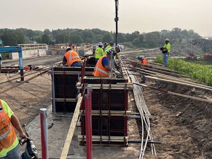 Crews pour concrete for a retaining wall near Etna Street in East St. Paul