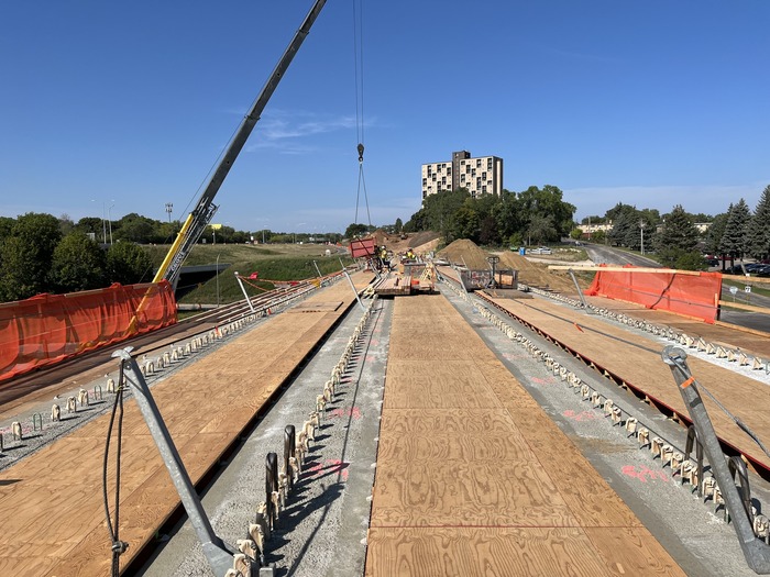 Crews install decking on the bus-only bridge near Etna Street in East St. Paul
