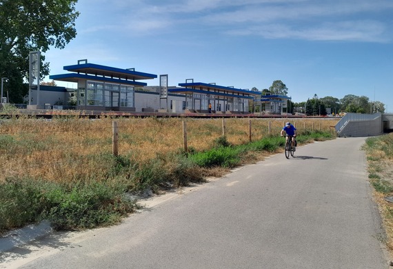 Photo of bicyclist on the South Cedar Lake Regional Trail with the Wooddale LRT Station in the background.