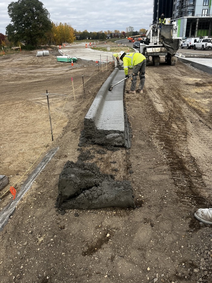 Crews install curbs on Helmo Avenue in Oakdale. 