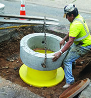 Worker repairs maintenance hole