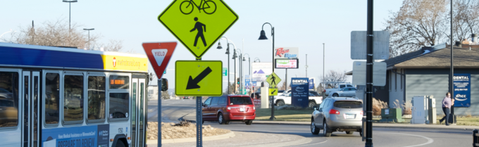 Roundabout in Richfield with cars, a bus, and a person walking in the background