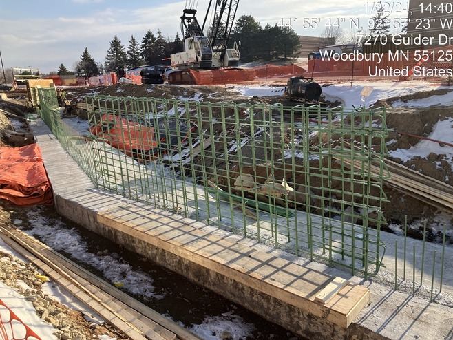 Crews construct foundations for a retaining wall along Guider Drive in Woodbury