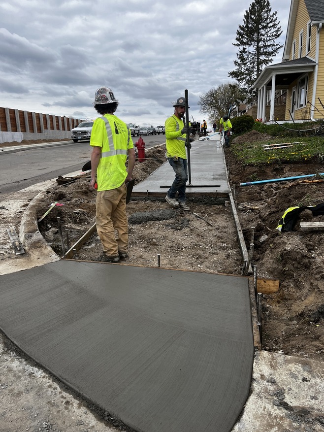 Crews pave sidewalks along Hudson Road between Earl Street and Frank Street