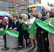 Officials cut a large green ribbon
