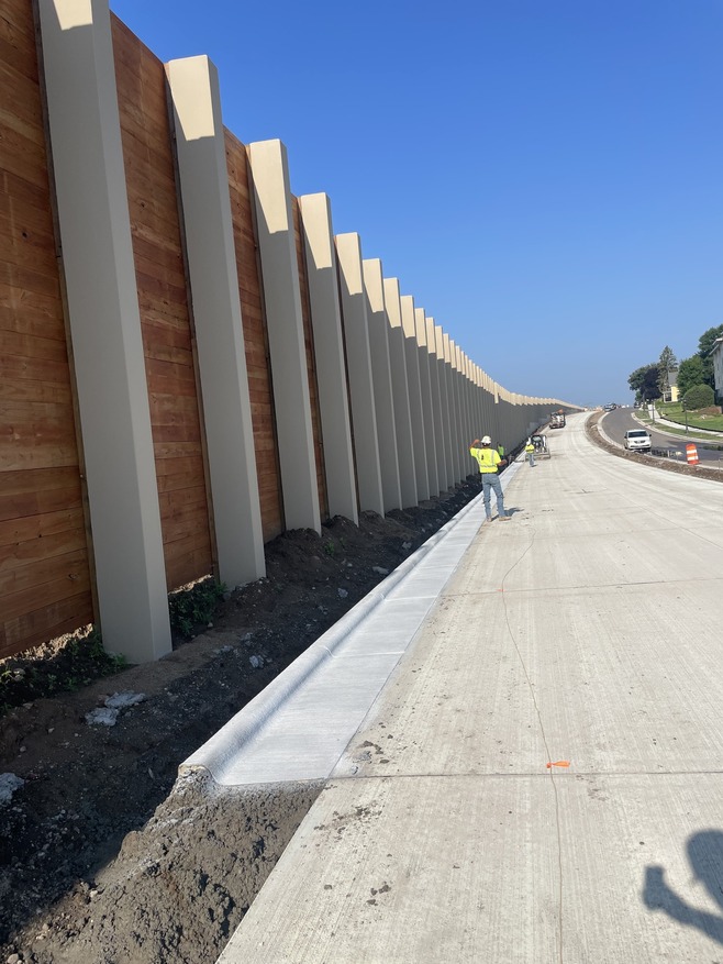 Crews pour concrete for curb on the bus guideway