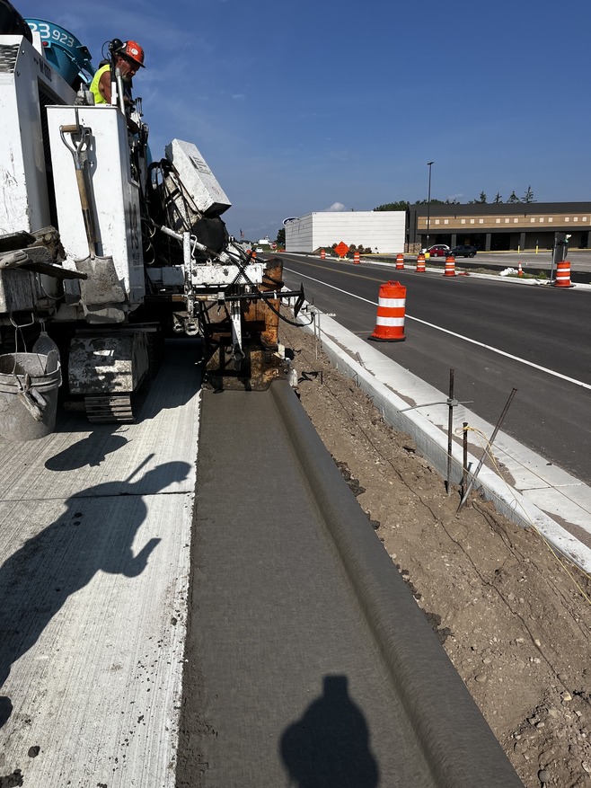 Crews pour and form curb near Sun Ray shopping center