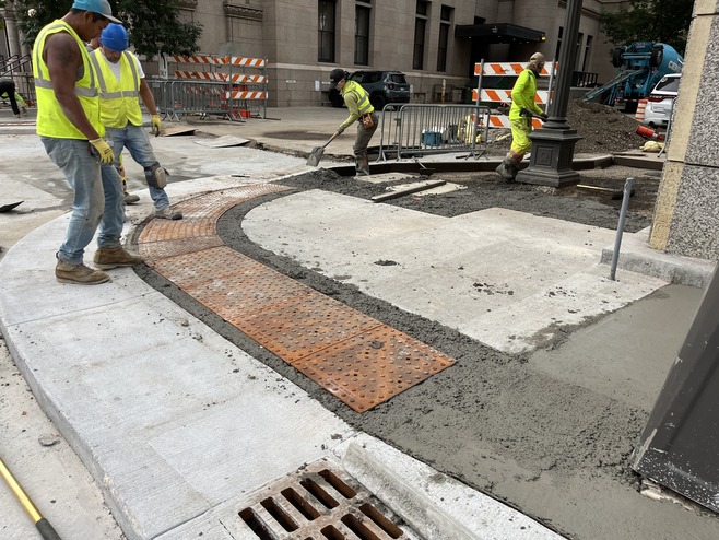 Crews install pedestrian ramps at 6th Street near Hamm Plaza