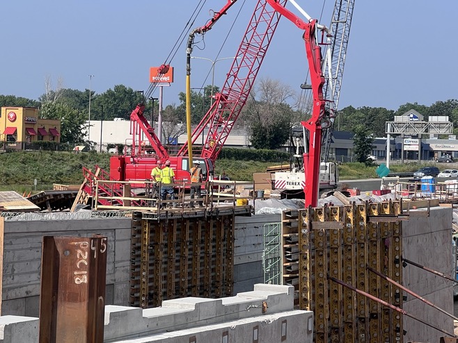 Crews pour concrete for wall at White Bear Avenue  