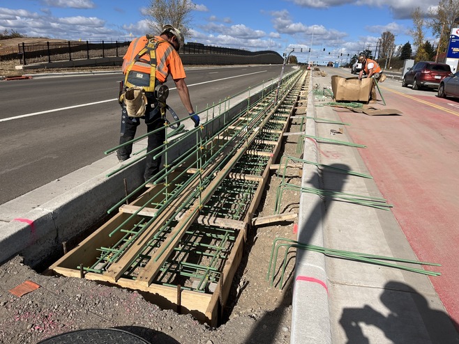 Crews construct walls between bus-only lanes and vehicle lanes on Bielenberg Drive near the Tamarack Station