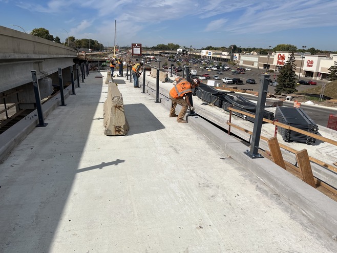 Crews install raillings on the McKnight pedestrian bridge.