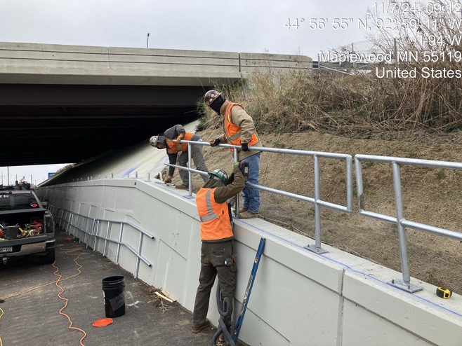 Crews install railings along Century Avenue/Highway 120. 