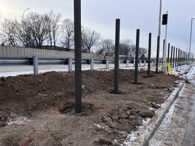 Crews install fence posts along Old Hudson Road near Sun Ray Shopping Center