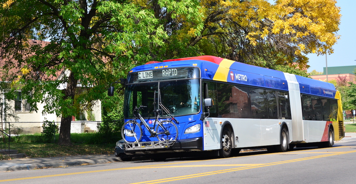 An image of a BRT bus stopping in front of a tree