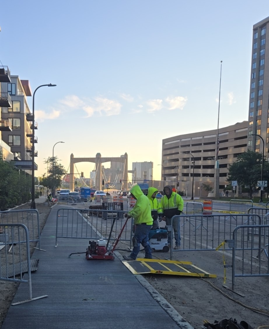 workers construct sidewalk