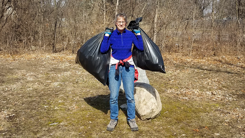 A volunteer holds trash bags filled with garbage collected along the Mississippi River.