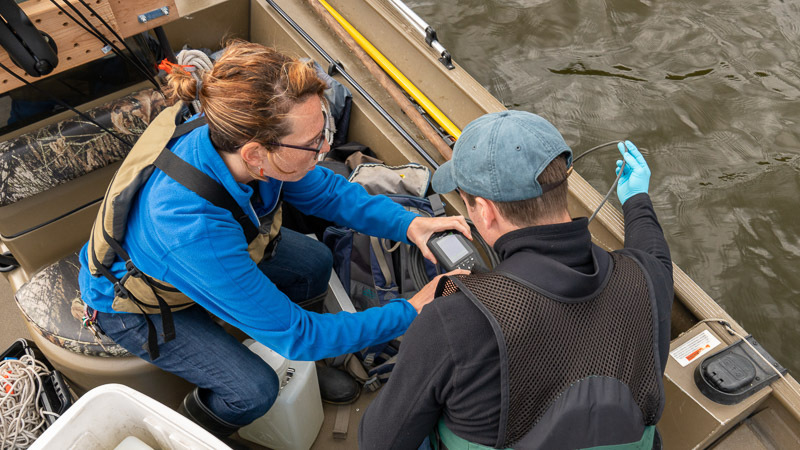 MWMO staff capturing water quality data from a boat in the Mississippi River.