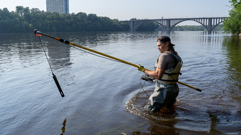 MWMO Intern John Johnson uses a water quality sonde in the Mississippi River.