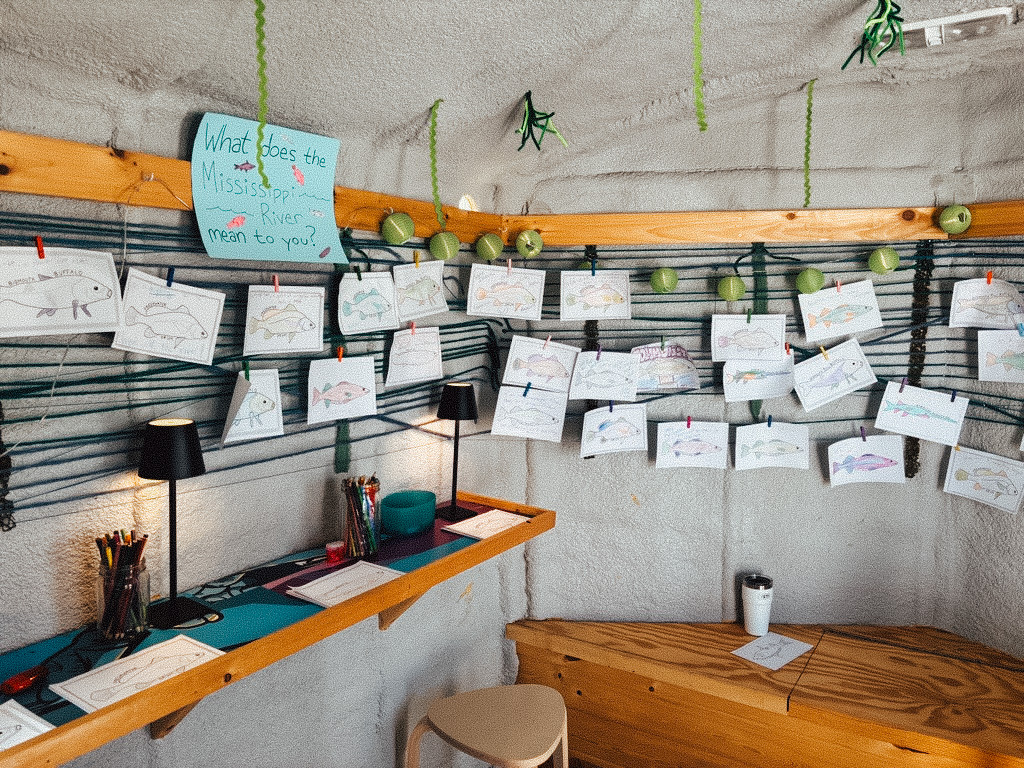 Fish drawings in an art shanty at lake Harriet with a sign that asks, "What connects you to the Mississippi River?"