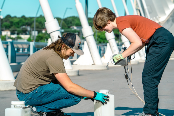 Intern sampling the Mississippi River with MWMO monitoring staff
