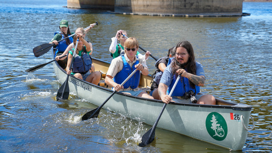 Community members paddling a canoe from Wilderness Inquiry with staff at Share the River