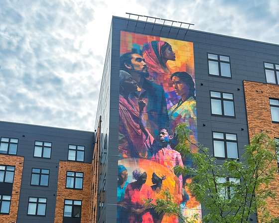 Colorful mural of people on the building side at opportunity crossing