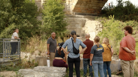 Barry Hand from Owámniyomni Okhódayapi leading a walking tour in the mill race