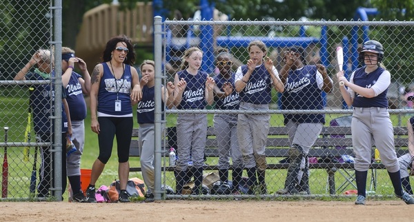 Youth Softball teammates lined up on the fence
