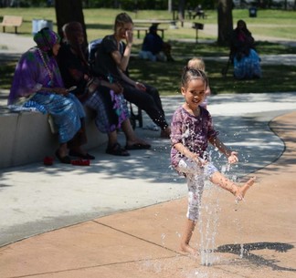 Currie Park splash pad with girl and onlookers