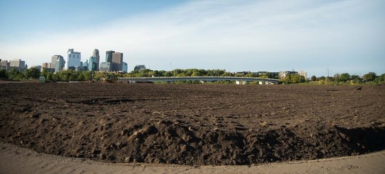 Graco Park under construction with a bulldozer in front of the Minneapolis skyline in September 2022
