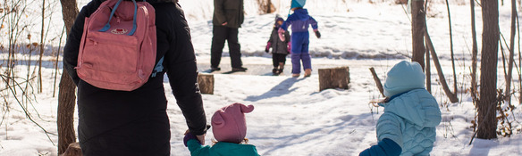 Children and adults walking in the woods in winter