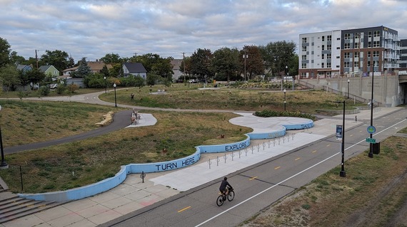 Parque Monarca (aka the Cepro site) from above. A biker rides past on the Midtown Greenway. 