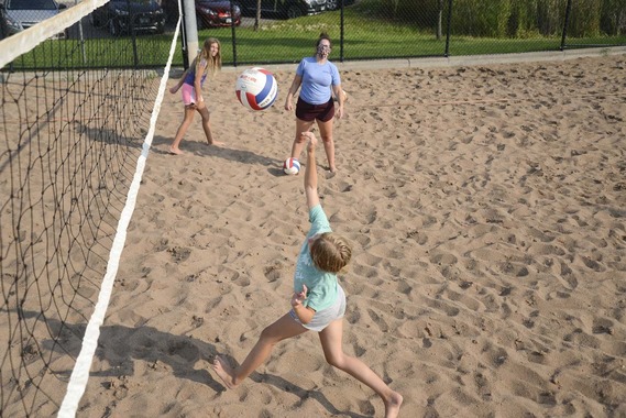 Youth playing sand volleyball