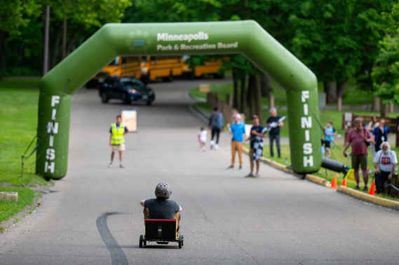 A soap box derby car heads toward the finish line