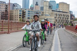 Kids riding bikes on the Stone Arch bridge in Minneapolis