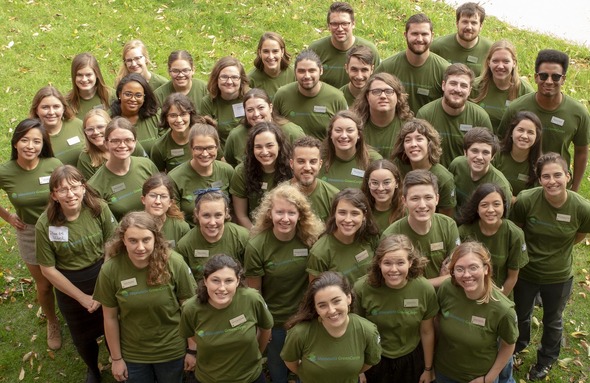 Group of members wearing green shirts looking up at the camera