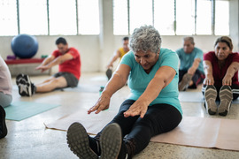 Group fitness class with many people stretching