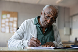 Older gentleman studying a book 