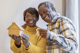 Happy couple holding a house and keys