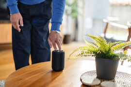 Man pushing button on alexa speaker