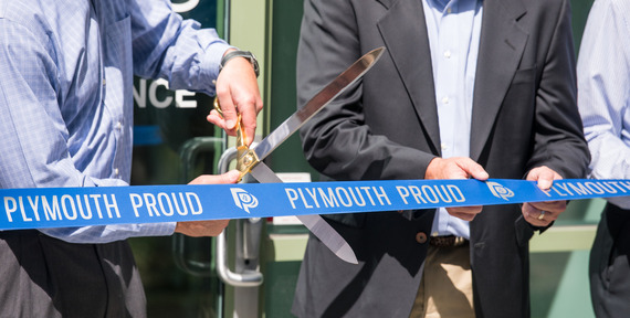Photo of a business cutting a ribbon that says "Plymouth Proud"