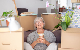 Happy woman smiling with cup of coffee amidst moving boxes